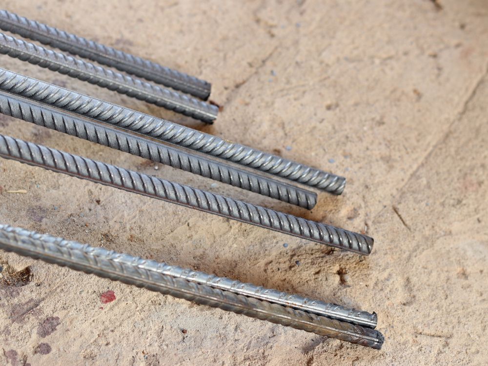Tipos de ferro utilizados na construção civil com barras metálicas e estrutura reforçada, destacando resistência e aplicação estrutural.